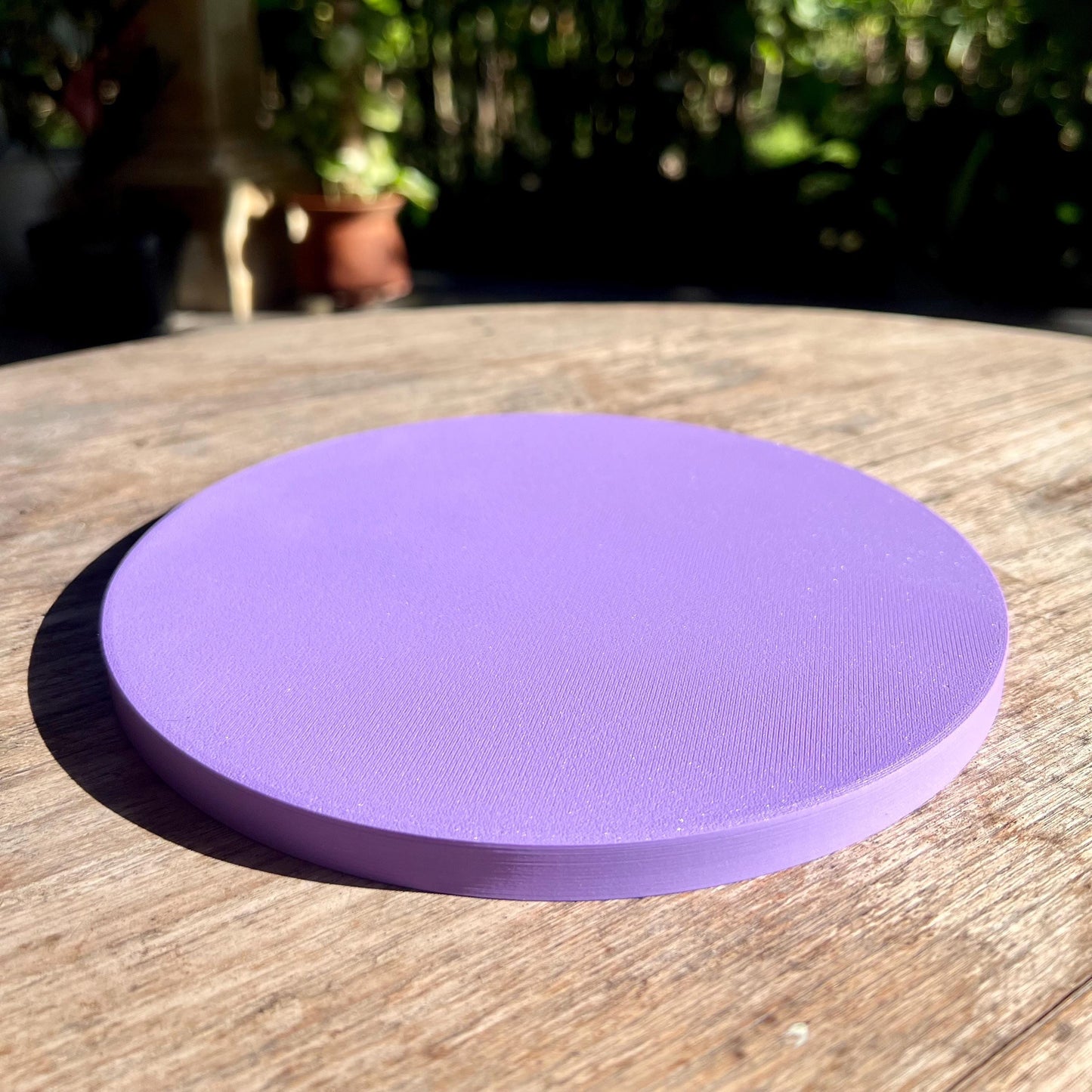 Flat underside of a star pattern drip tray with a textured base, designed to sit securely on indoor surfaces
