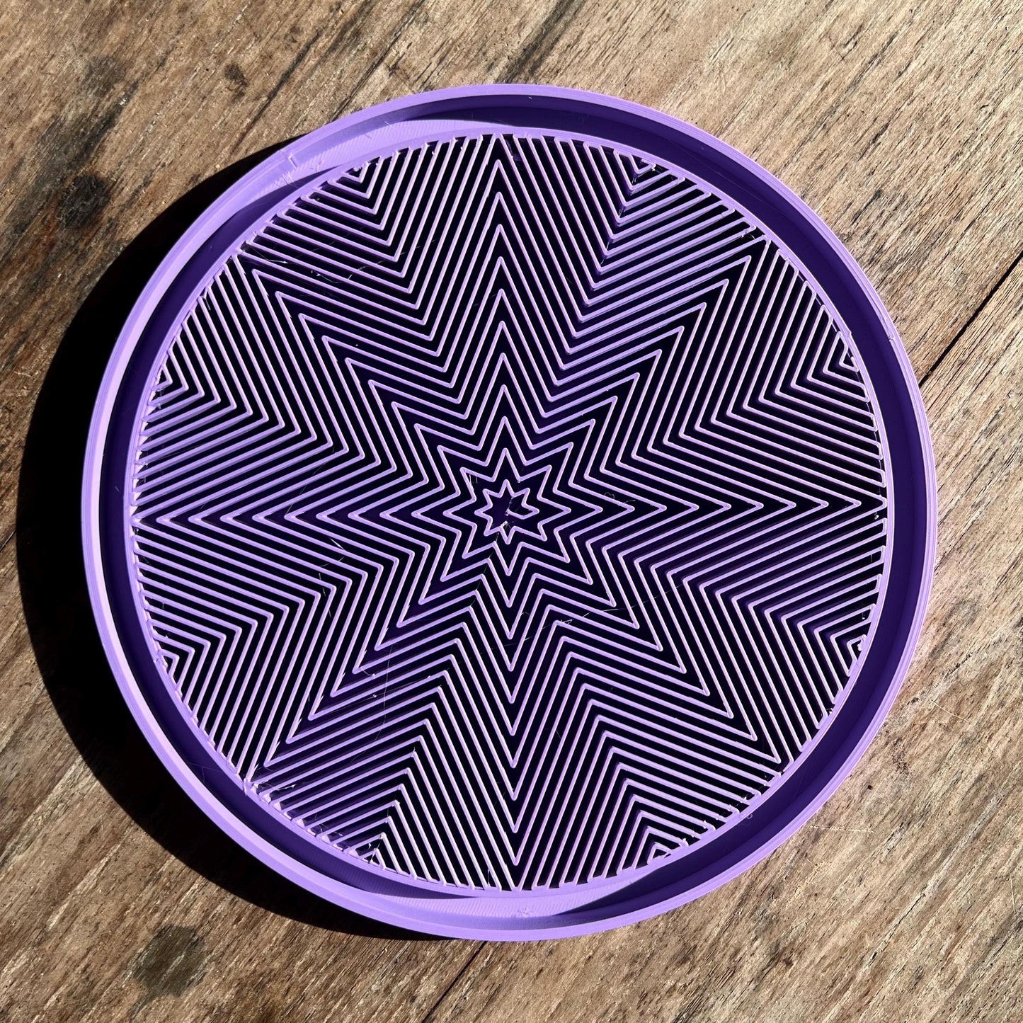 Top view of a star pattern drip tray showing the radial textured surface for water collection