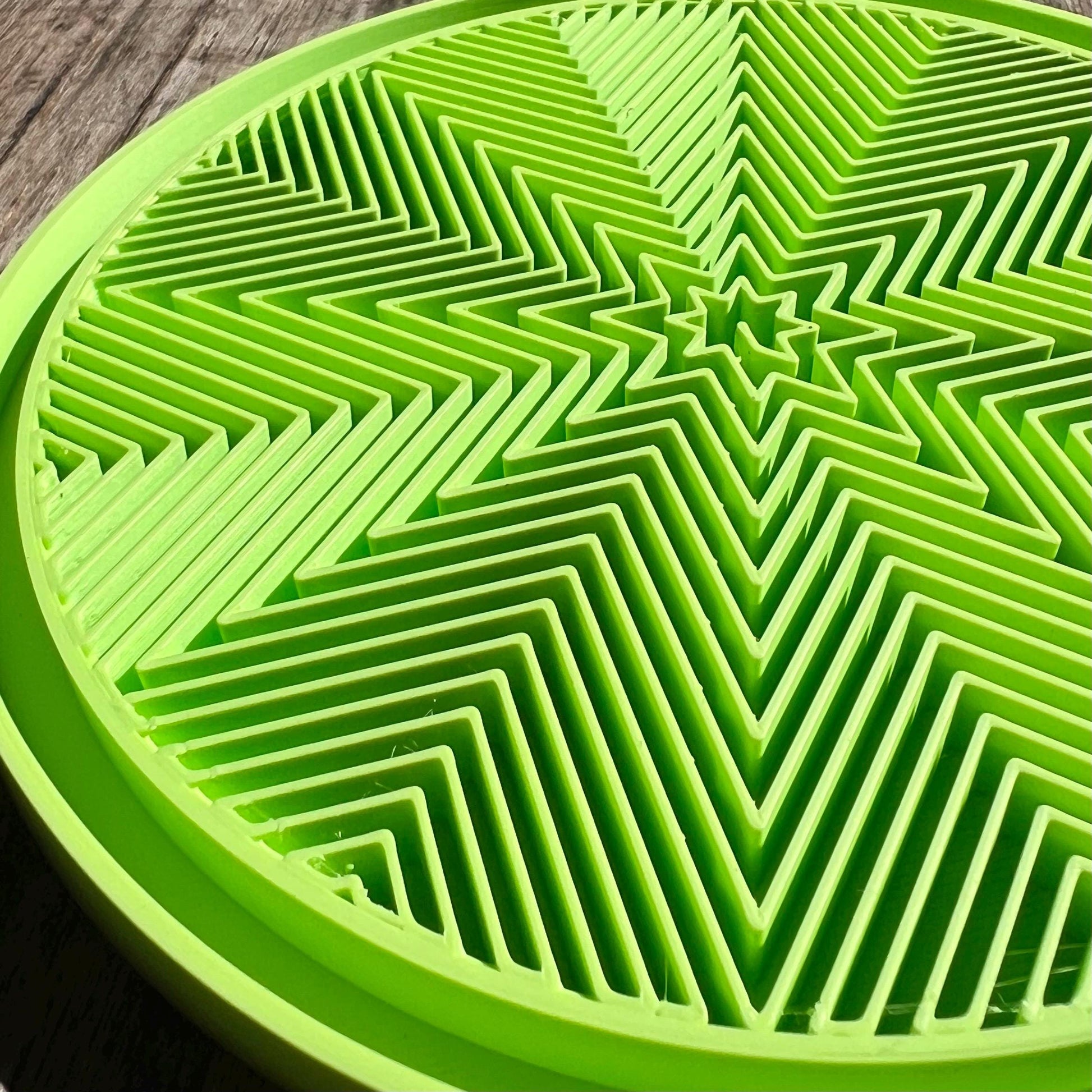 Close up of a green star pattern drip tray highlighting the geometric surface texture