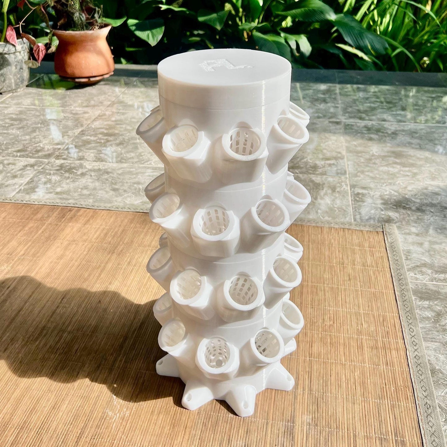 3D printed vertical hydroponic tower system displayed on a wooden surface, highlighting its modular stacked design